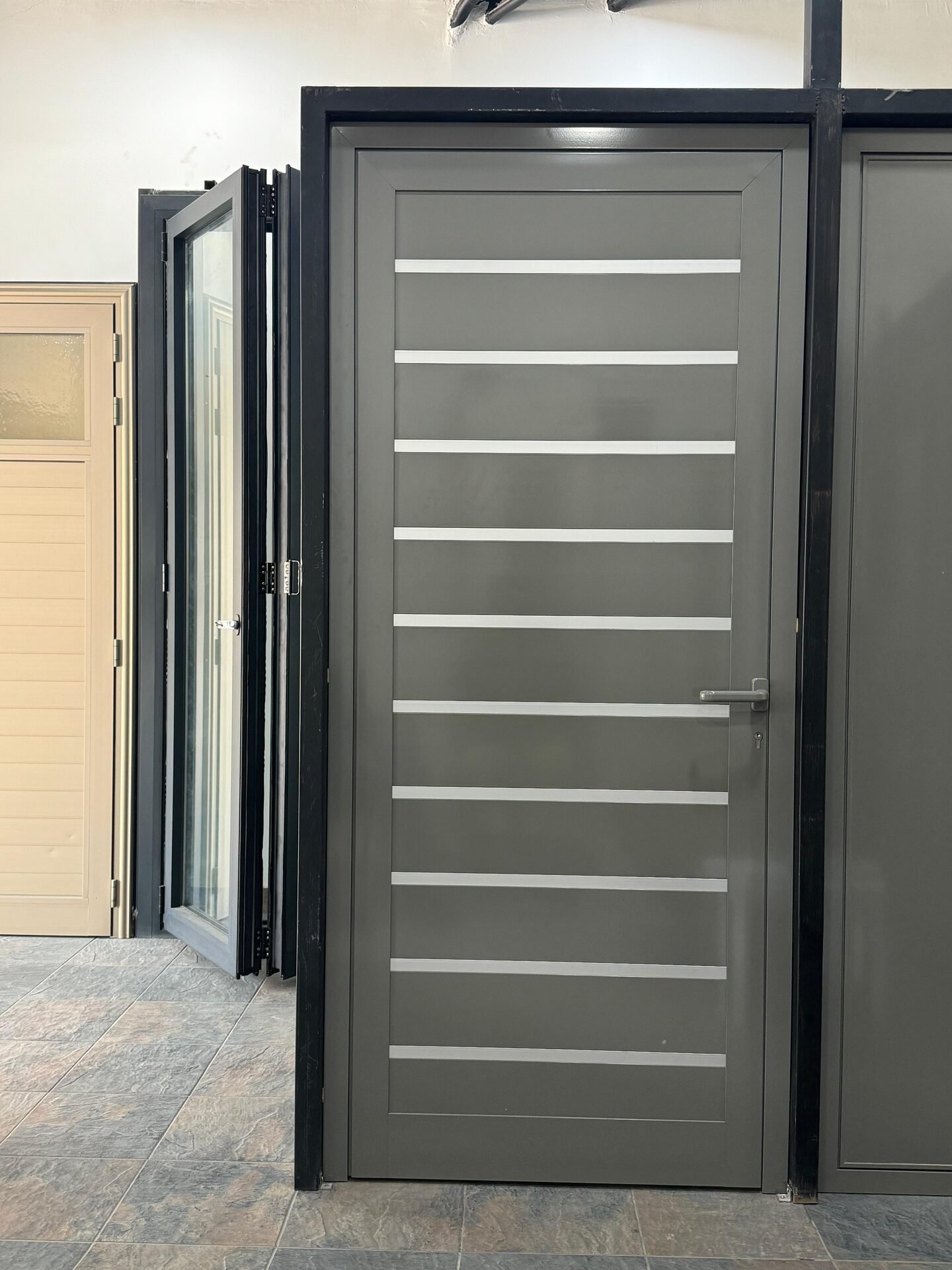 Grey slatted aluminium door beside a folding door